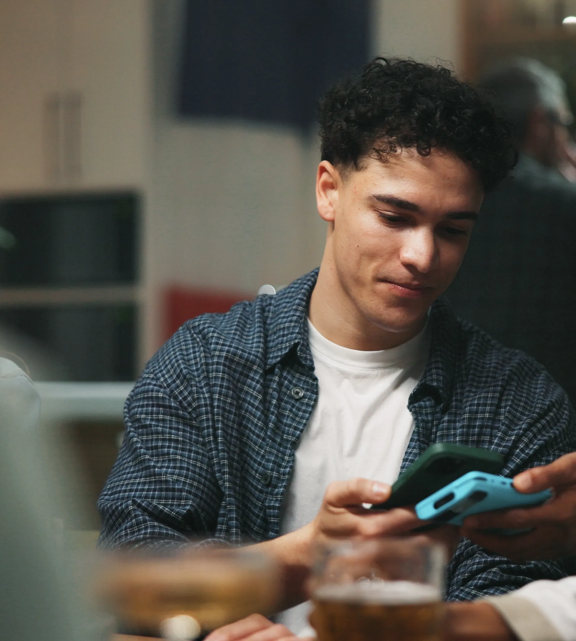 Friends sharing a phone in a bar